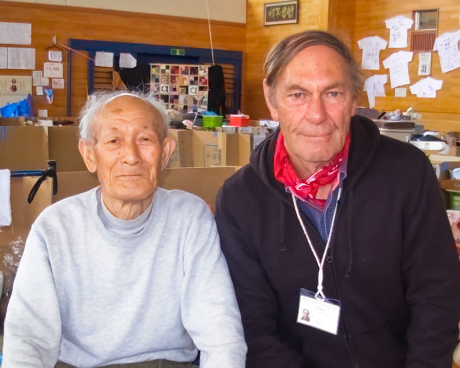 Peter Dunn (right) with a man he helped in a school gymnasium converted to a shelter for those displaced by the March 2011 earthquake.