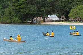Scientology Volunteer Ministers Good Will Tour leaders and team of locally trained Volunteer Ministers paddle canoes across the bay to the village of Lambi in Guadalcanal.